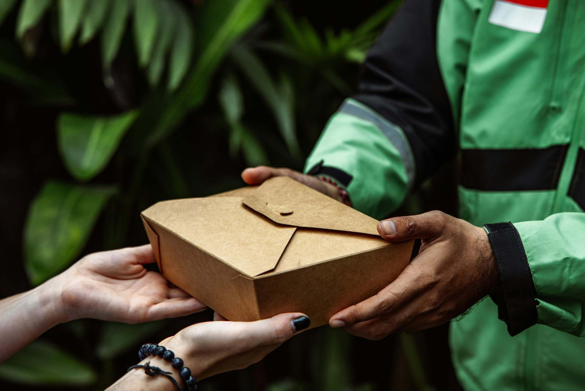 DoorDash delivery driver handing food order to customer
